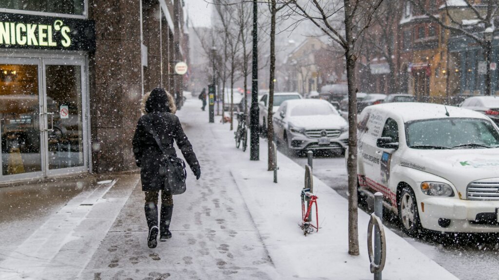a person walks down a snow-filled road while shopping in kitchener-waterloo, the area needs a commercial snow removal contractor