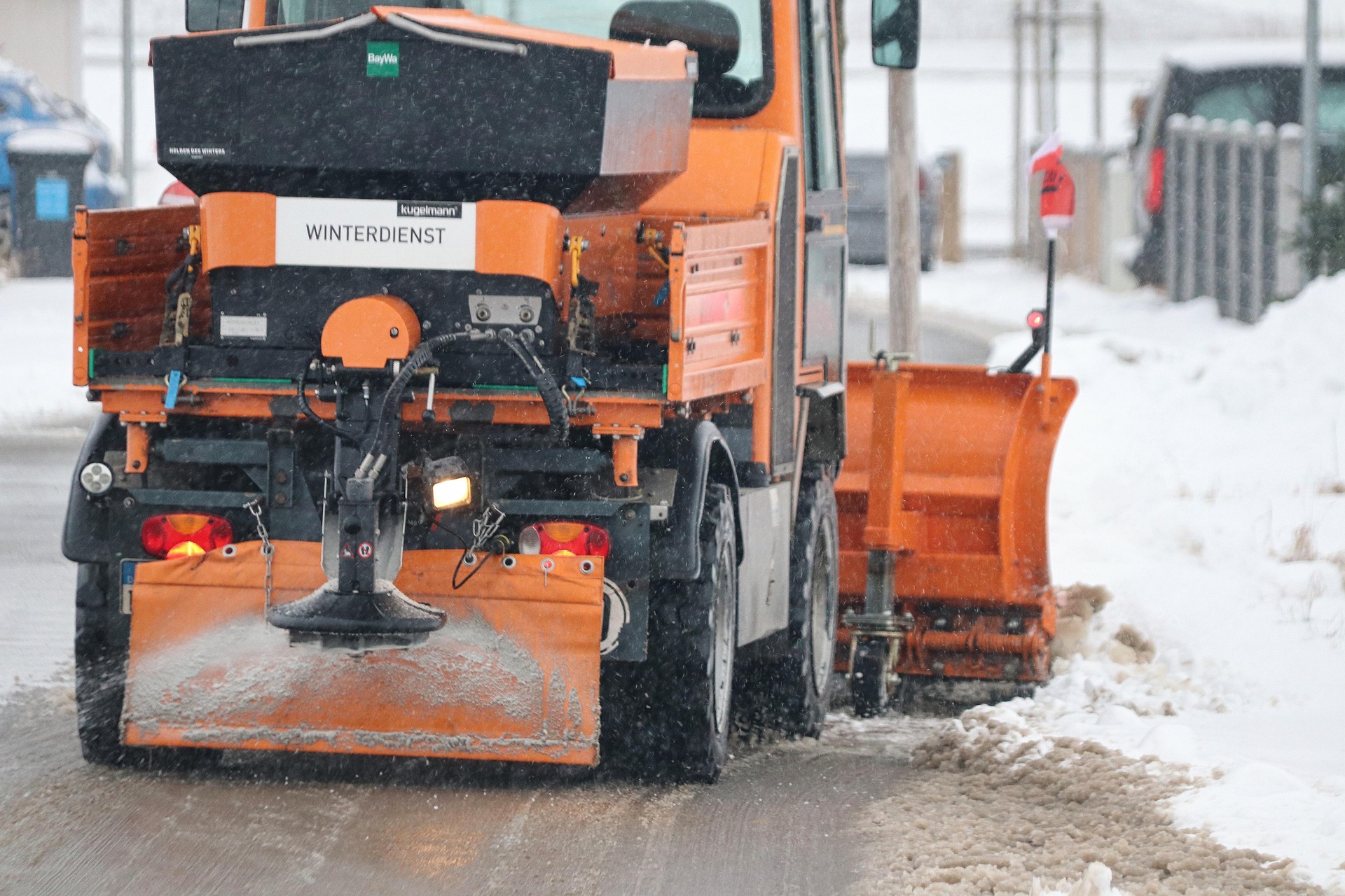 this snow plow clears the road for pedestrians and customers, showing the importance of commercial snow removal for small businesses in kitchener waterloo